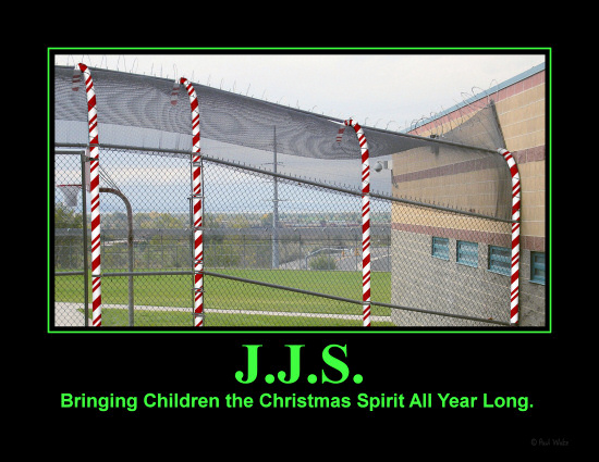 Picture of the fence around a secure confinement facility, with the curved metal poles colored to resemble candy canes.