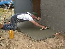 Bruce, KI7OM, putting final finish on the cement pad in front of the door - small version